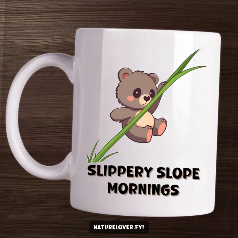 Funny bear cub mug showing a clumsy cub sliding down a single, giant blade of grass, a humorous and cute design.